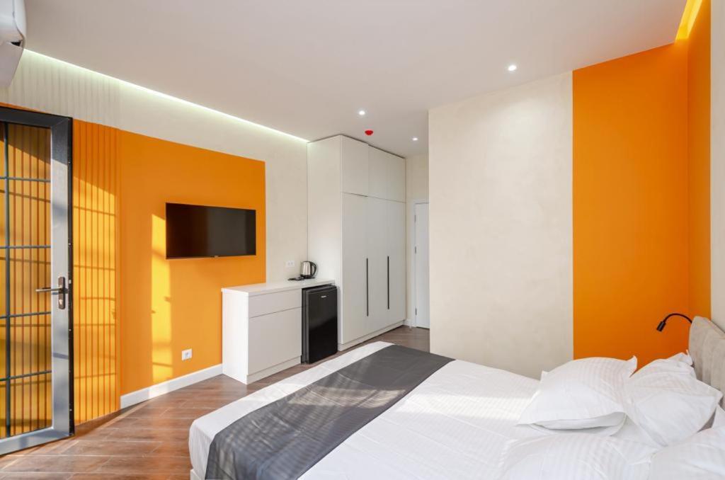 a bedroom with a bed with an orange wall at Latorre Hotel in Yerevan