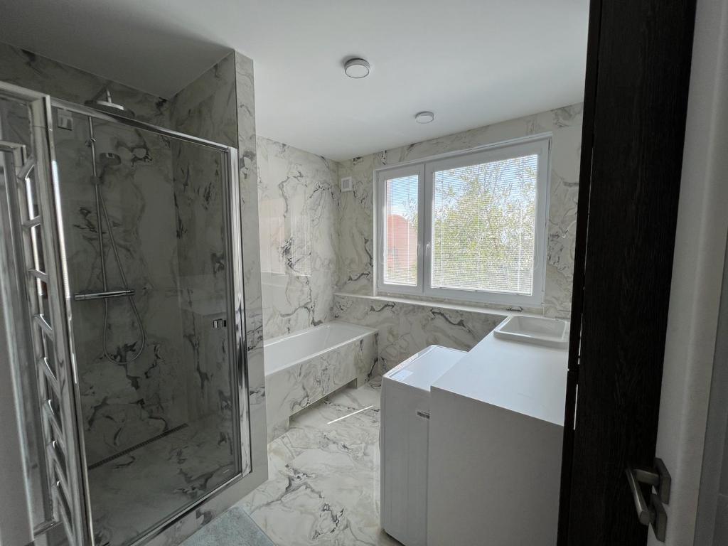 La salle de bains est pourvue d'une douche et d'un lavabo. dans l'établissement Modern apartment in Košice, à Košice