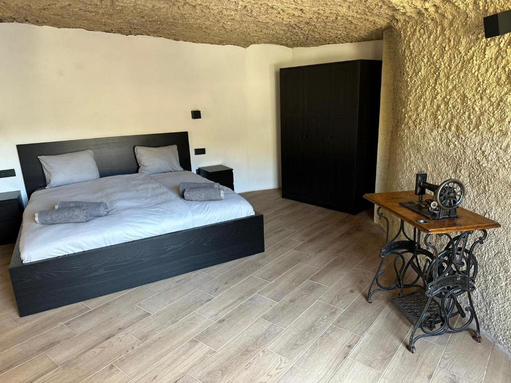a bedroom with a bed and a table with a telephone at Höhlenapartment in Güimar