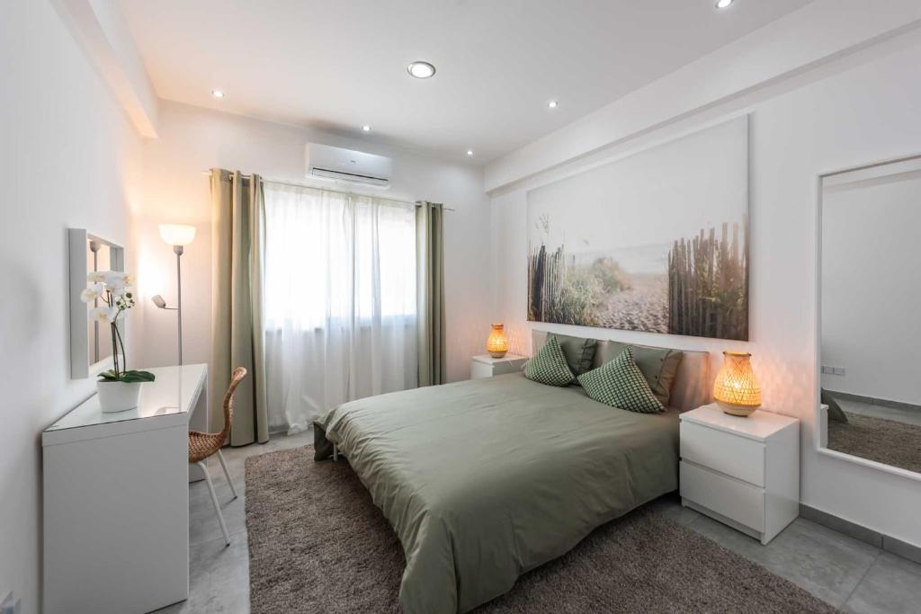 a bedroom with a large bed and two night stands at Kition City Apartments - Central Location in Larnaca