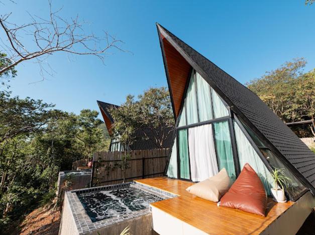 ein kleines Haus mit einem Dach auf einem Balkon in der Unterkunft Phuzita Kohlarn-ภูศิตา เกาะล้าน in Ko Larn