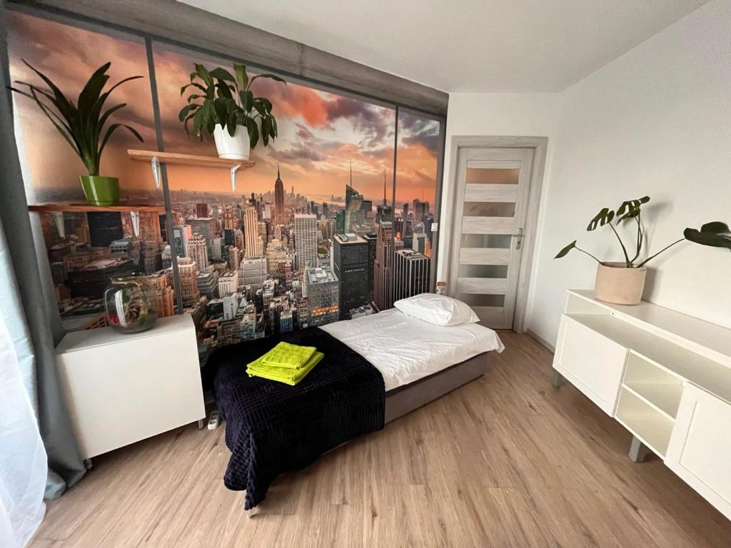 a bedroom with a wall mural of a city at Last floor apartment with balcony in Krakow