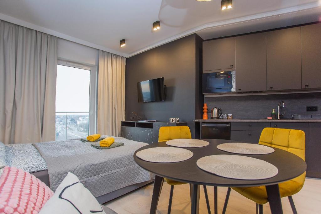 een keuken en een woonkamer met een tafel en stoelen bij Urban Jungle apartament Delta in Białystok