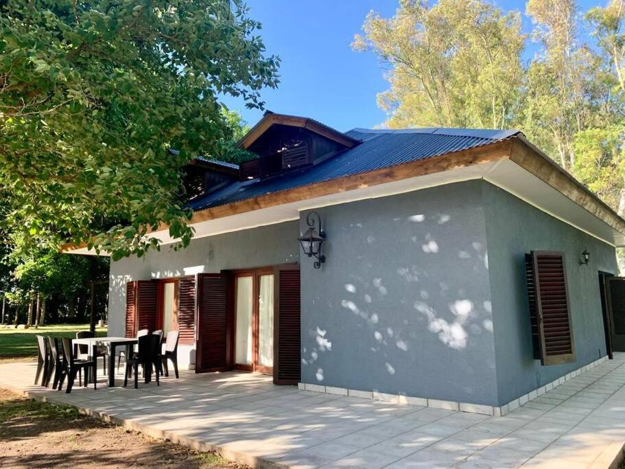 una casa con una mesa y sillas en un patio en La Rosada Casa de Campo en General Las Heras