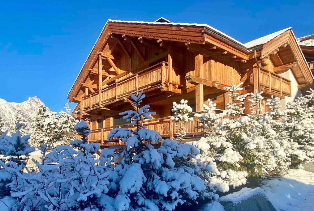 una cabaña de madera en la nieve en Chalet Charme & SPA - Serre Chevalier 1500, en Le Monêtier-les-Bains