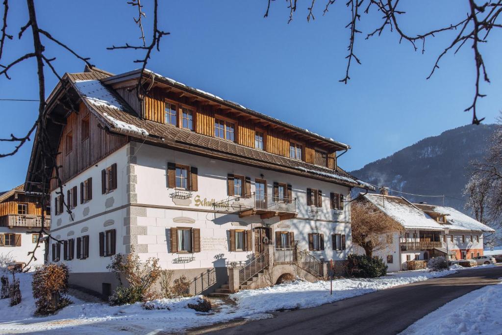 a building in the winter with snow on the ground at Schullerhof in Hermagor