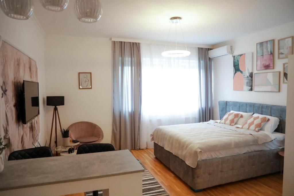 1 dormitorio con cama, escritorio y ventana en Apartman Ena en Bele Vode