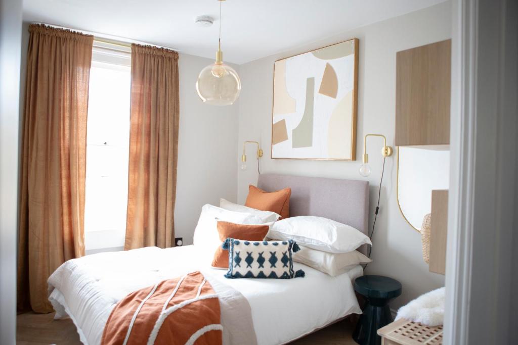 a bedroom with a bed with orange and white pillows at 1 Bed Apartments - Central Bath in Bath