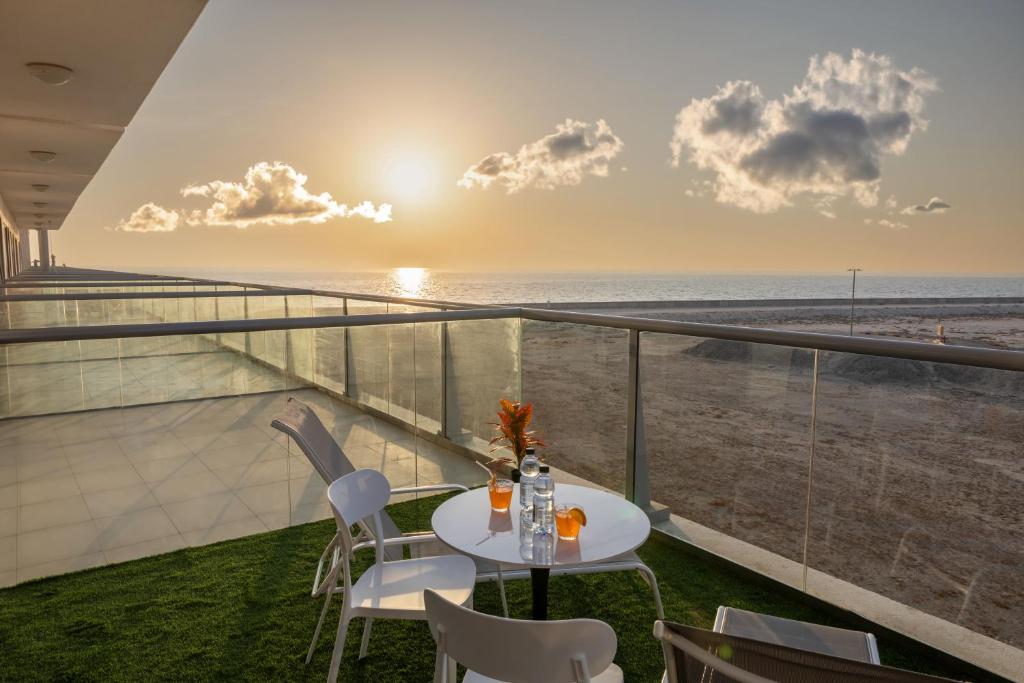 a table and chairs on a balcony with a view of the beach at Marjan Island - Studio Open Sea View in Ras al Khaimah