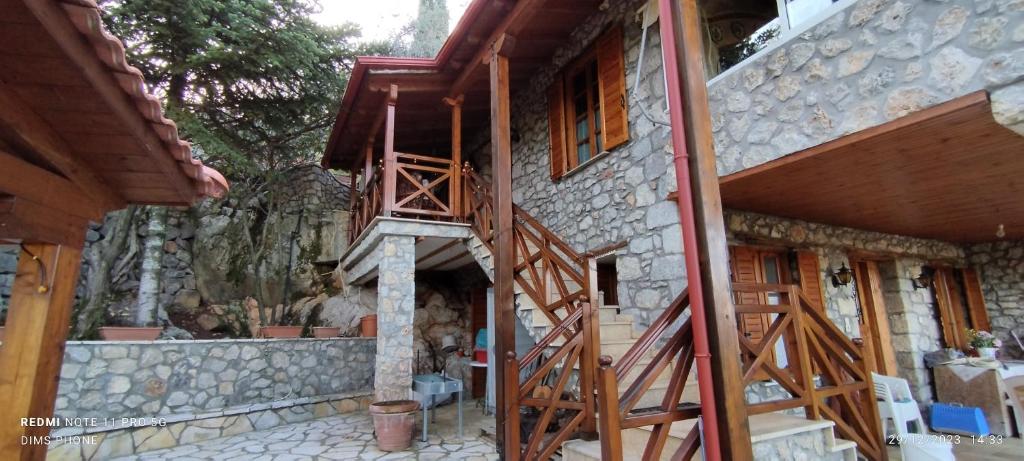 uma casa com uma escada de madeira ao lado em Η θέα em Lílaia