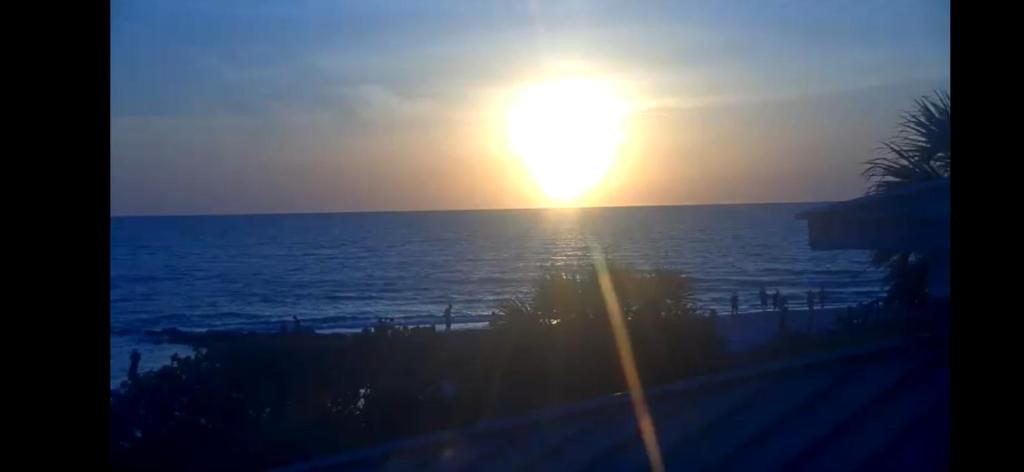 a sunset over the ocean with the sun in the sky at Beachside chillin in St. Pete Beach