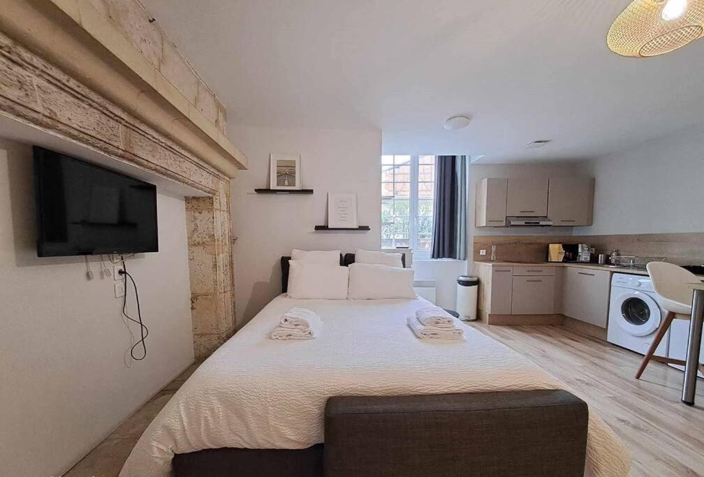 une chambre avec un grand lit avec une télévision au mur dans l'établissement Studio - Centre Ville - Terrasse, à Agen