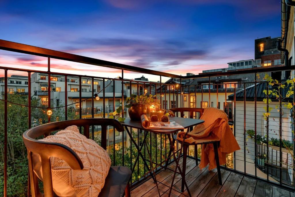 - un balcon avec une table et des chaises dans l'établissement **MODERN ***CENTRAl ***ROOFTOP *** YOU'll LOVE IT, à Oslo