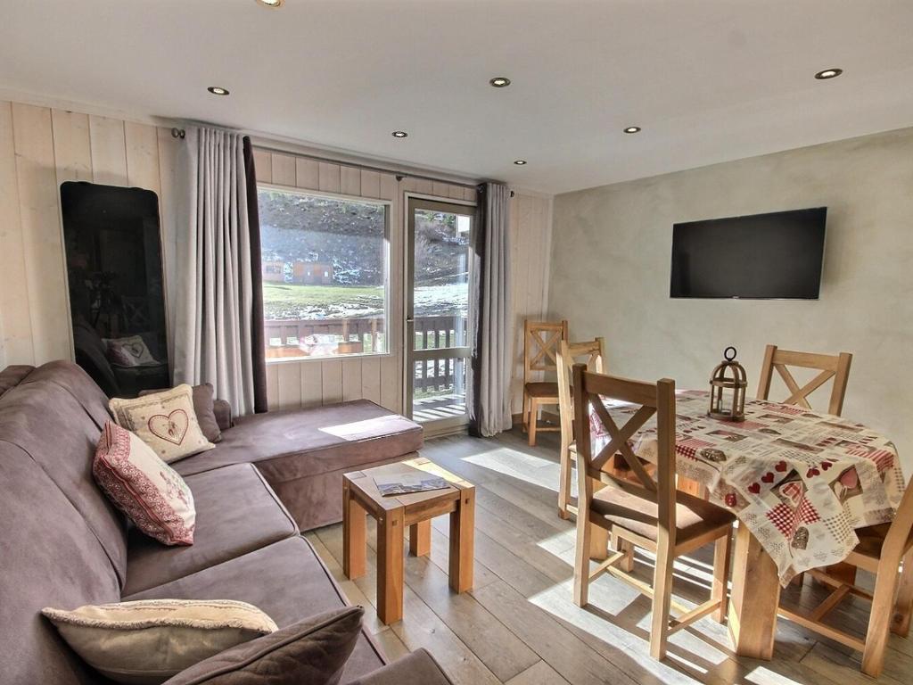 a living room with a couch and a table at Bel appartement cosy de 50m² pour 4 pers, pied des pistes Méribel Mottaret avec terrasse et parking - FR-1-411-913 in Les Allues