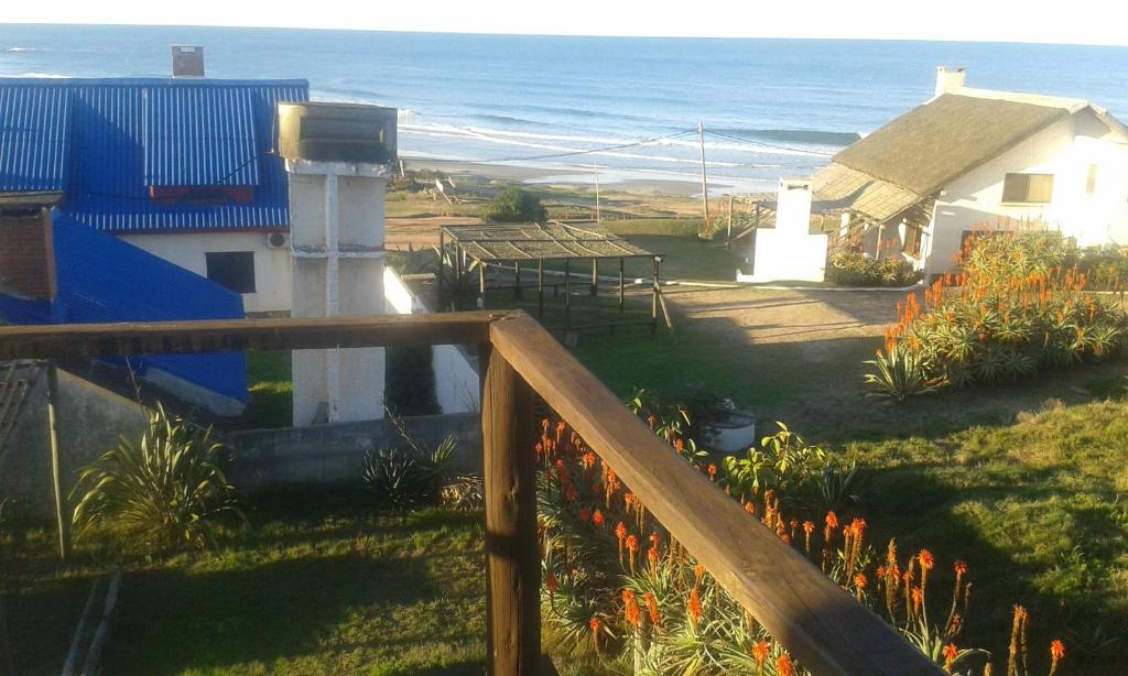 een balkon van een huis met de oceaan op de achtergrond bij Ancora in Punta Del Diablo