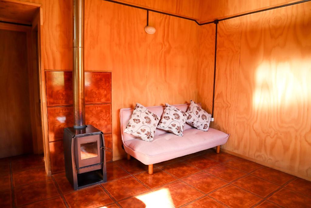 a room with a couch with a stove in it at Cabañas tres hermanos in Futaleufú