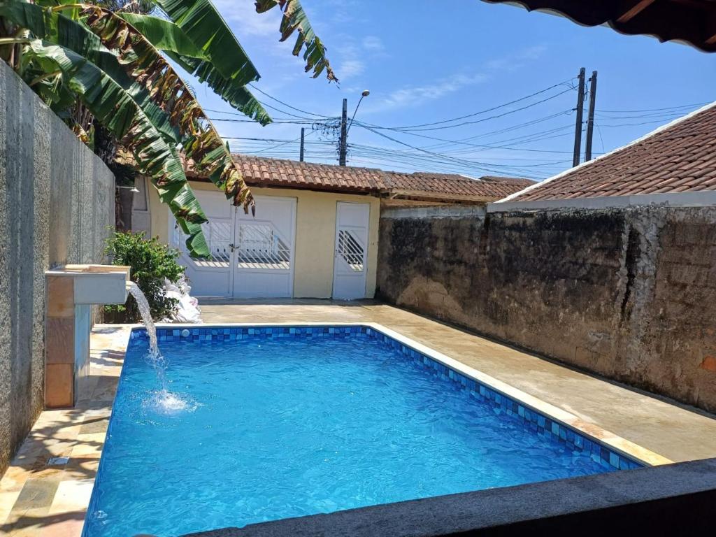 - une piscine avec une fontaine dans l'arrière-cour dans l'établissement Casa Térrea, Biu2planet, à Mongaguá