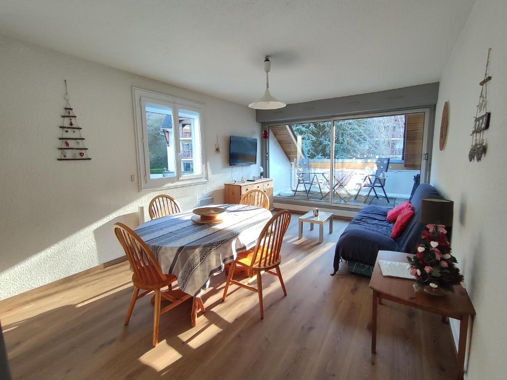 un salon avec une table, des chaises et un canapé dans l'établissement T2 spacieux et lumineux avec 2 terrasses Sud et Est, proche centre village, à Saint-Lary-Soulan