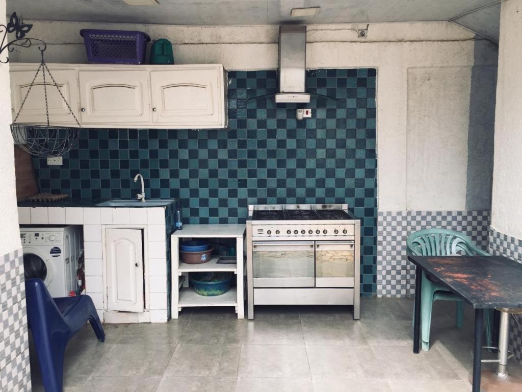 a kitchen with a stove and a table in it at La Résidence in Lomé