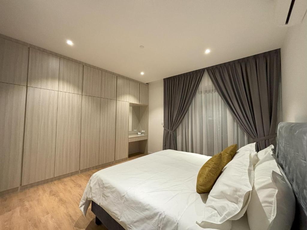 Quill Residence KL by Bamboo Hospitality في كوالالمبور: غرفة نوم بسرير ابيض كبير مع دواليب خشبية