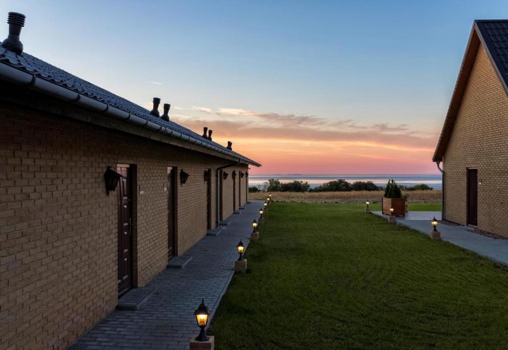 a row of brick buildings with lights on the grass at Bornholm Apartments in Svaneke
