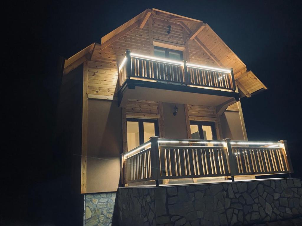 a house with a balcony with lights on it at Planinska kuća Srna in Bajina Bašta