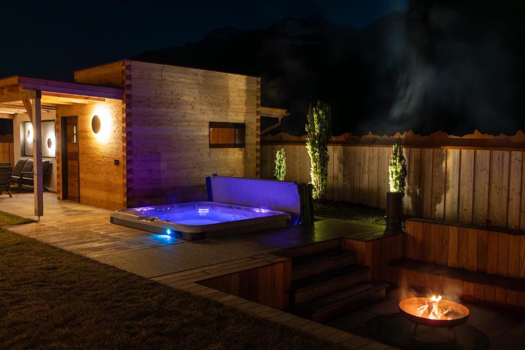 a hot tub sitting on a deck at night at Chalet ORUS - Tirol Kärnten in Irschen