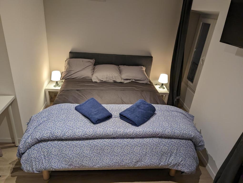 a bed with two blue pillows on top of it at Holiday Nice Studio in Nice