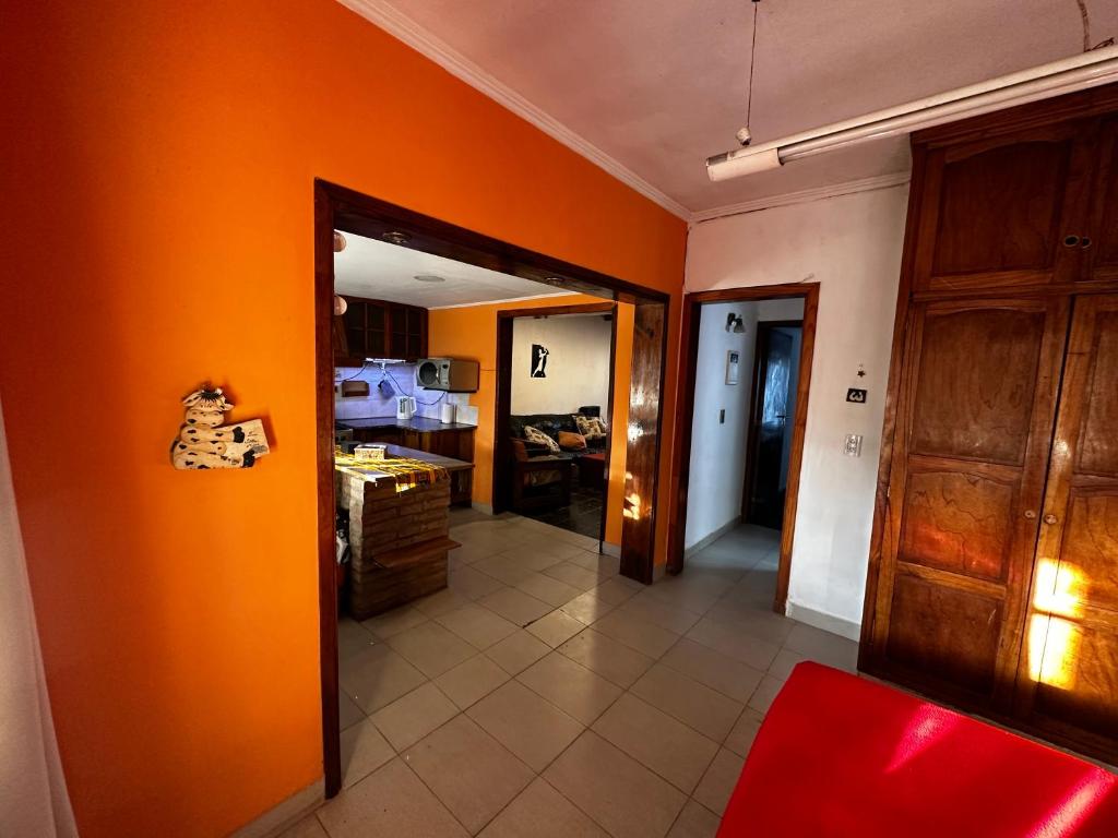 a kitchen with an orange wall and a hallway at Casa hasta 11 personas in Necochea