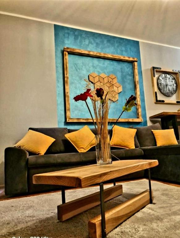 a living room with a couch and a vase with flowers on a table at Center Lux Apartment Marijana in Novi Sad