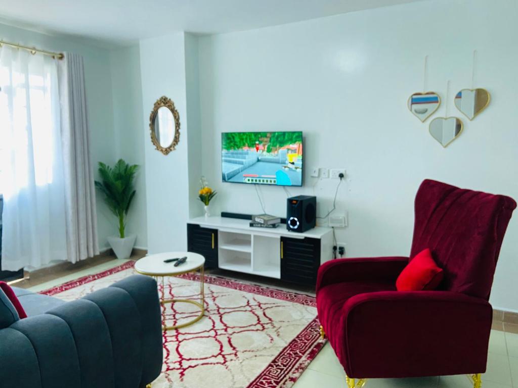 sala de estar con 2 sillas y TV en Luxurious furnished home thika road en Nairobi