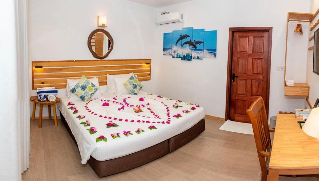 Un dormitorio con una cama con flores. en Oceano Beach Vashafaru en Vashafaru