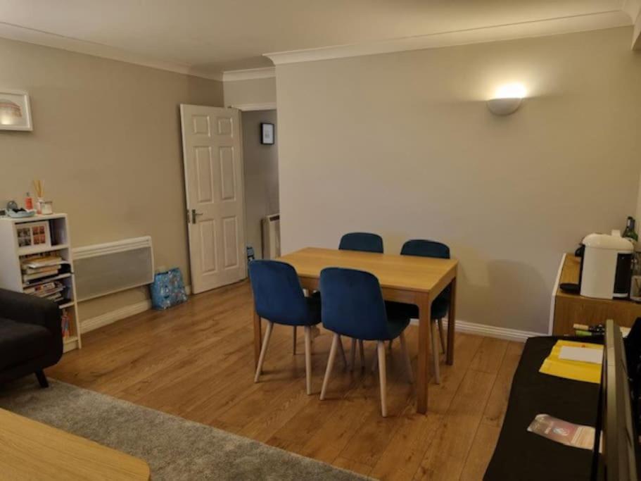 a dining room with a table and blue chairs at Modern two bed flat in Canada Water close to transport in London