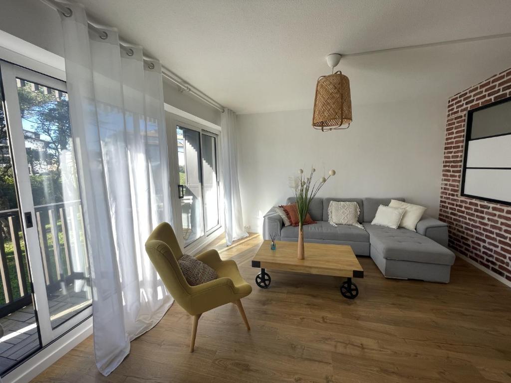 a living room with a couch and a table at Douce brise à Seignosse-2 min à pied de la plage in Seignosse