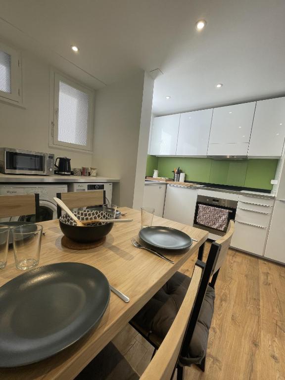 a kitchen with a wooden table with plates on it at Douce brise à Seignosse-2 min à pied de la plage in Seignosse