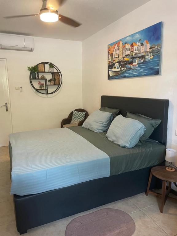 een slaapkamer met een bed en een schilderij aan de muur bij Dushi Cocobana in Willemstad