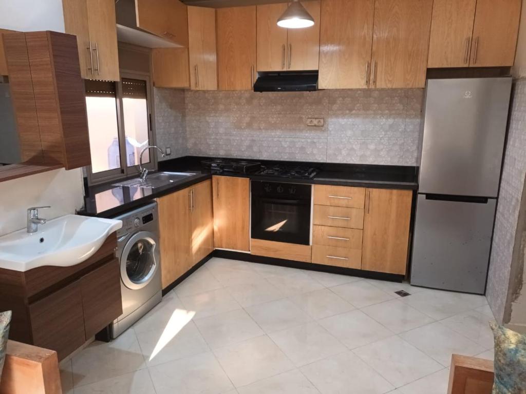 a kitchen with a sink and a stove and a dishwasher at Al-Nasr in Agadir