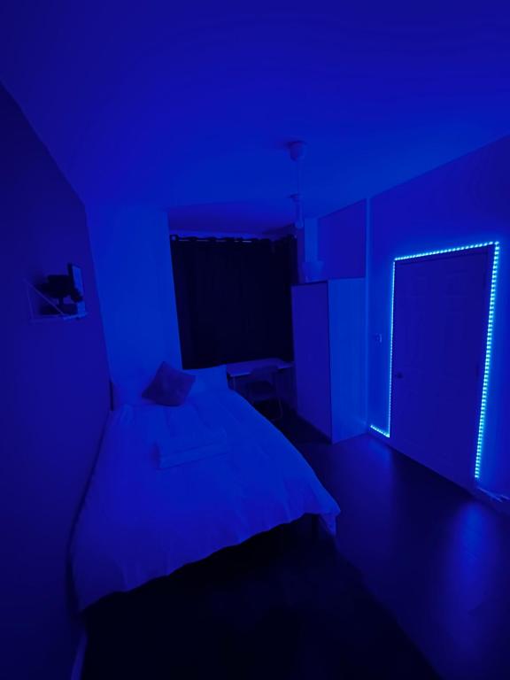 a blue room with a bed and a window at Ensuite room in West Midlands in Parkside