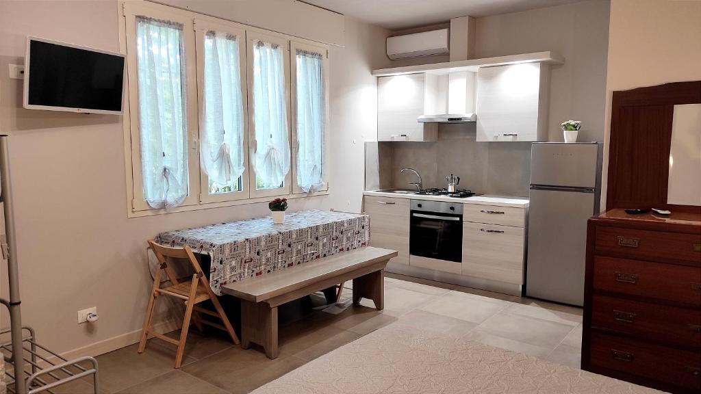 a small kitchen with a table and a sink at Gli Ulivi Rooms in Lucca