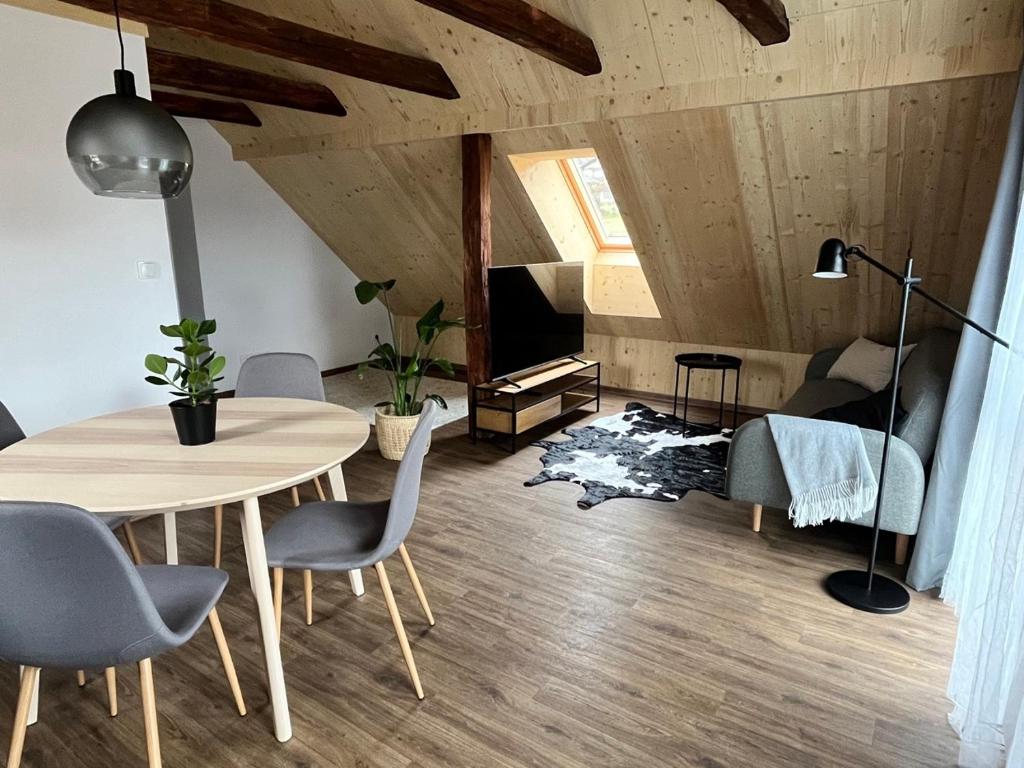 a living room with a table and chairs and a bed at Sáňky Apartmány in Liberec