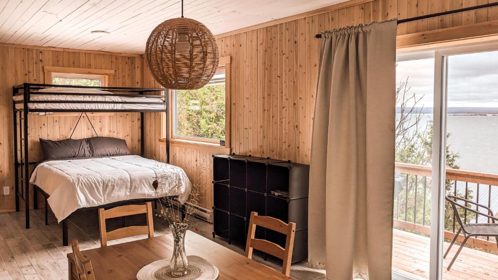 ein Schlafzimmer mit einem Etagenbett und einem Fenster in der Unterkunft Chalet La Renarde in Nouvelle