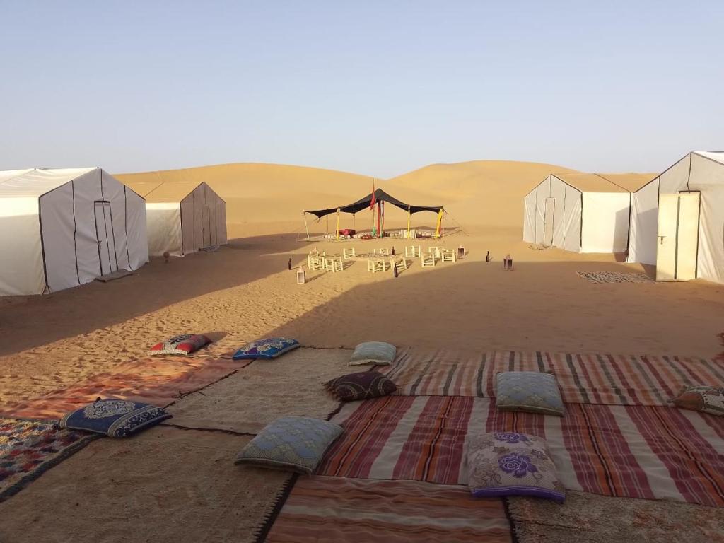 a group of tents in the middle of a desert at Itri camp in Zagora