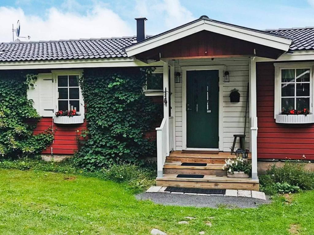 ein rotes und weißes Haus mit grüner Tür in der Unterkunft Holiday home NÄSSJÖ III in Nässjö