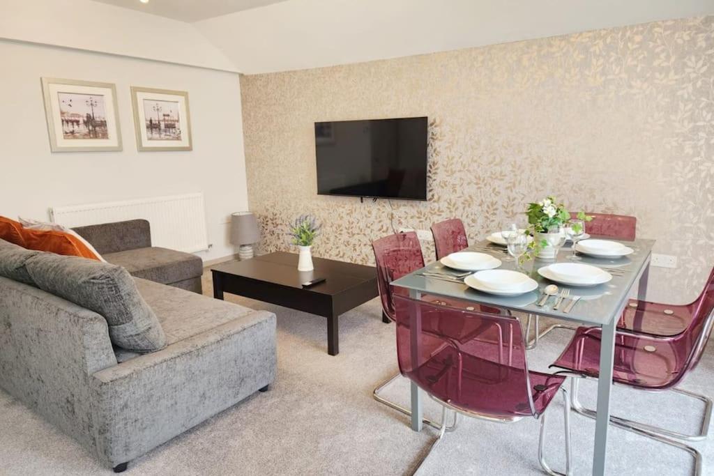 een woonkamer met een tafel en stoelen en een televisie bij Horizon House, Modern 2-Bedroom Flat 2, Parking, Netflix, Oxford in Oxford