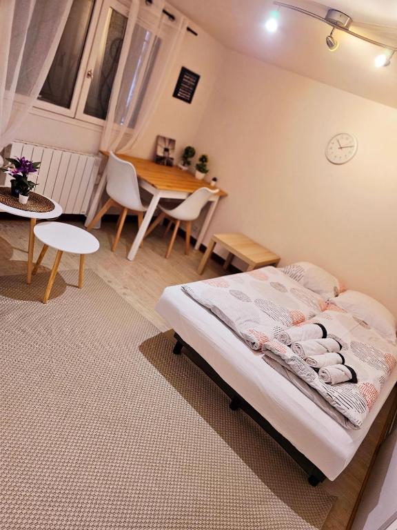 une chambre avec un lit, une table et des chaises dans l'établissement Appartement à proximité de la Gare du RER B Le Guichet ,Paris Saclay, à Orsay