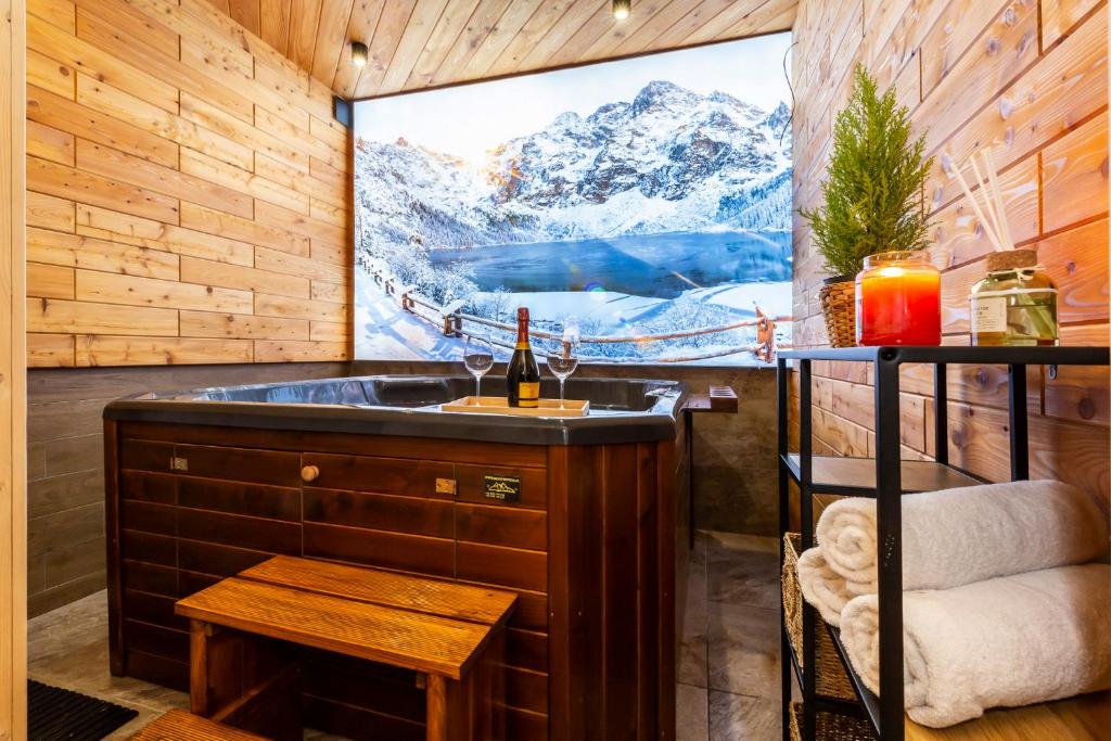ein Badezimmer mit einer Badewanne und einem großen Fenster mit einem TV in der Unterkunft Willa u Jadzi in Zakopane