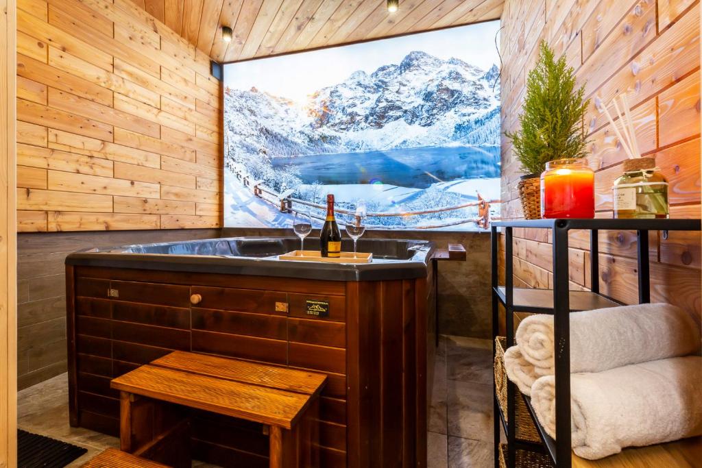 a bathroom with a tub with a large window with a tv at Willa u Jadzi in Zakopane