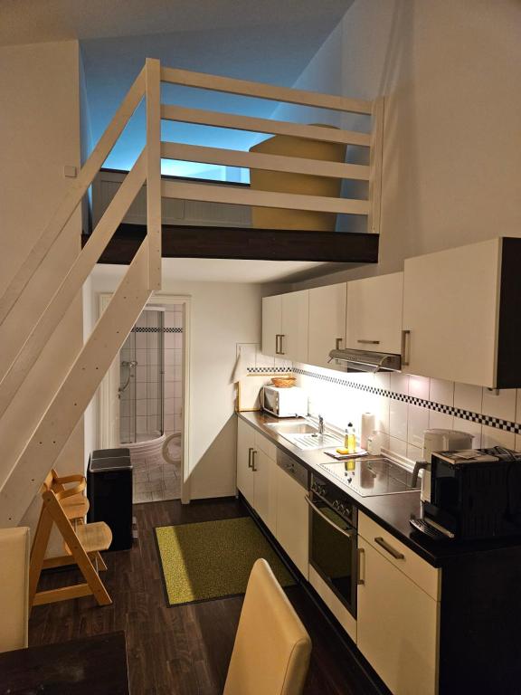 Una cocina con fregadero y una escalera en ella. en Waldhof Golf-Fewo, en Korswandt