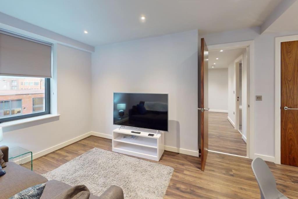 a living room with a flat screen tv on a white wall at Entire 1 bd aprt in Jewellery Q. in Birmingham