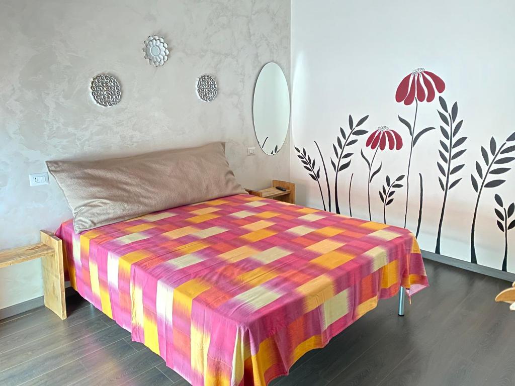 um quarto com uma cama com um cobertor colorido em Casa Incoronata em Campobasso